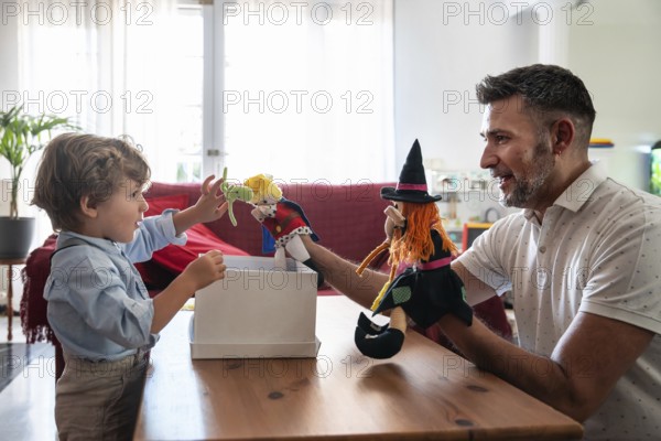 A heartwarming scene of a father engaging in playful puppet storytelling with his young son.