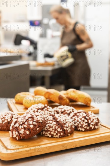 A variety of freshly baked Italian pastries are displayed on wooden trays in a bustling bakery In