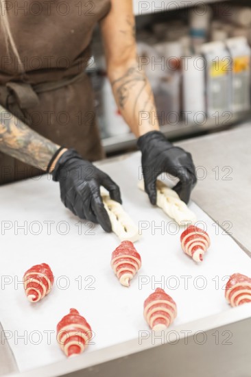 A skilled artisan wearing gloves crafts intricate pastries on a preparation table in an Italian
