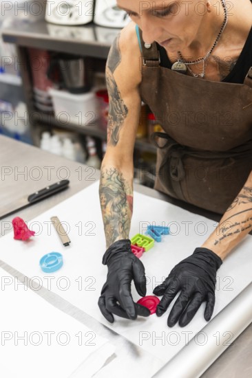 A skilled artisan in an Italian bakery decorates fondant Wearing gloves and an apron, they craft