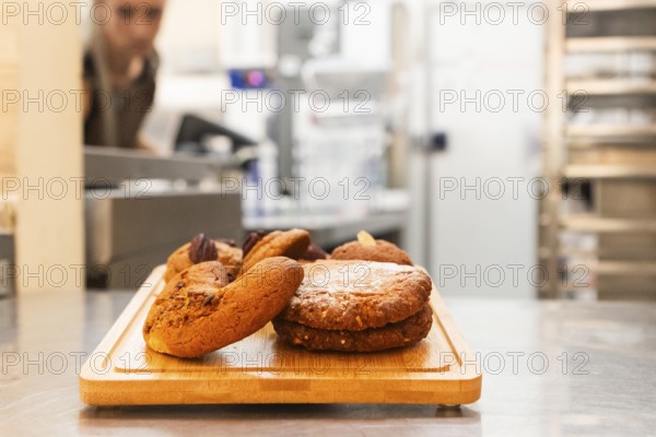 A close-up of freshly baked Italian cookies displayed on a wooden tray in a bakery setting The