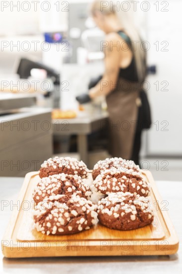 A display of freshly baked Italian pastries topped with sugar crystals on a wooden board A baker