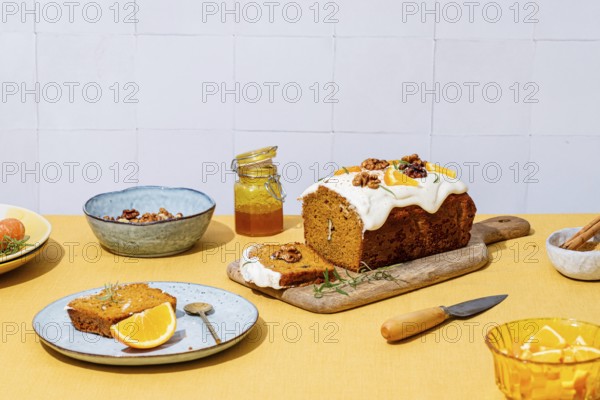 A mouthwatering carrot cake loaf topped with creamy cheese frosting, walnuts, and rosemary Vibrant
