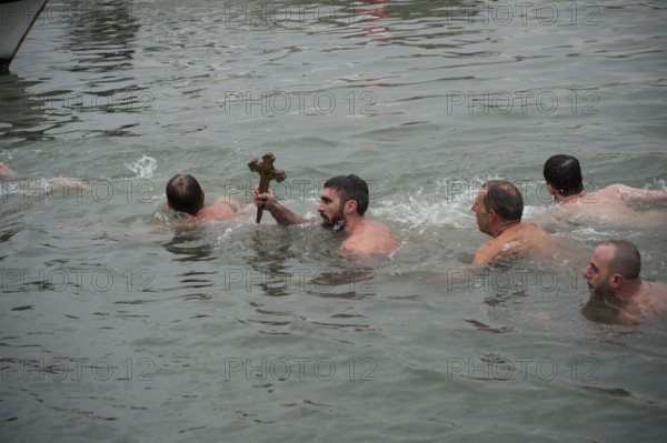 Istanbul, Turkey, January 6th 2017 A man holds a wooden cross after retrieving it from the Golden