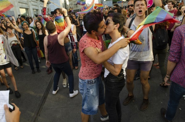 Istanbul, Turkey. 28th June, 2015 Two Gay Turkish men kiss among people celebrating Gay Pride in