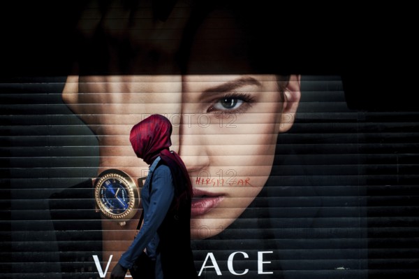 Istanbul, Turkey. April 28th 2016 A Turkish Muslim woman wearing a red Hijab walking past an