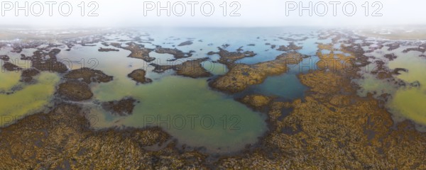 Discover the tranquil beauty of Icelandic wetlands, captured from above in early autumn The mist