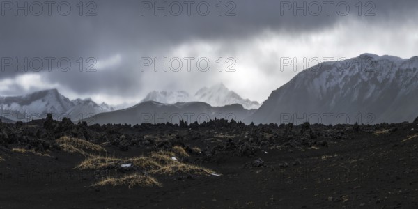 Majestic panoramic view of Iceland's highlands with volcanic terrain and distant snow-covered peaks