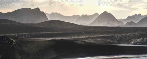 Captivating panoramic view of the Icelandic Highlands at sunset Mist gently blankets the mountains,