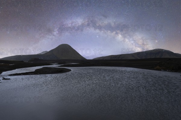 A breathtaking view of the Milky Way arching over a serene Icelandic landscape The clear, starlit