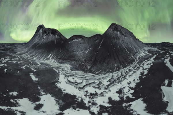Awe-inspiring aurora borealis dances in the night sky above snow-dusted mountains and rugged
