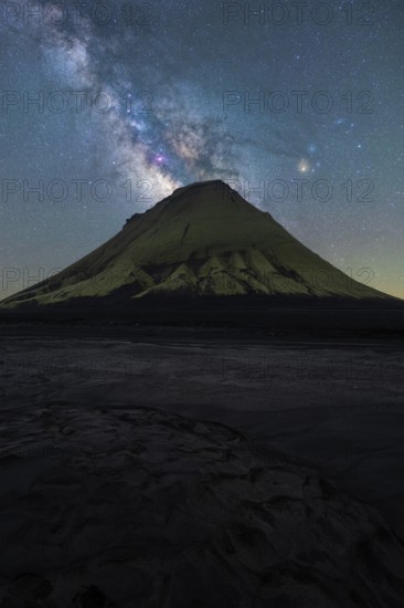 A striking view of an Icelandic mountain silhouetted against the vibrant Milky Way The serene night