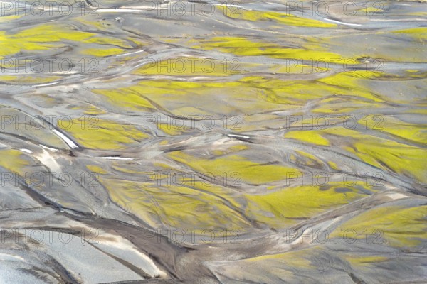 Aerial view showcasing intricate textures and patterns created by vibrant Icelandic rivers. Natural