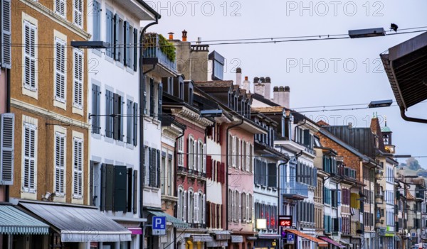A vibrant street view of Rolle, Switzerland, showcasing colorful historic buildings with charming