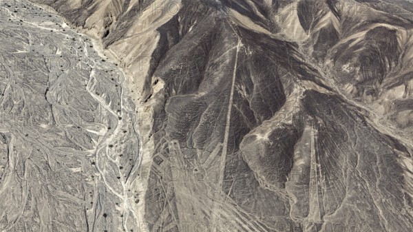 Aerial view of a desert landscape with complex line patterns and geoglyphs, the geoglyphs and