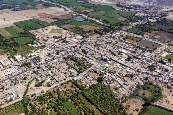Aerial view of a city surrounded by agricultural land and a highly visible road network, The city