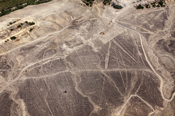 Nazca lines spread across the desert landscape in detailed patterns, the geoglyphs and drawings in