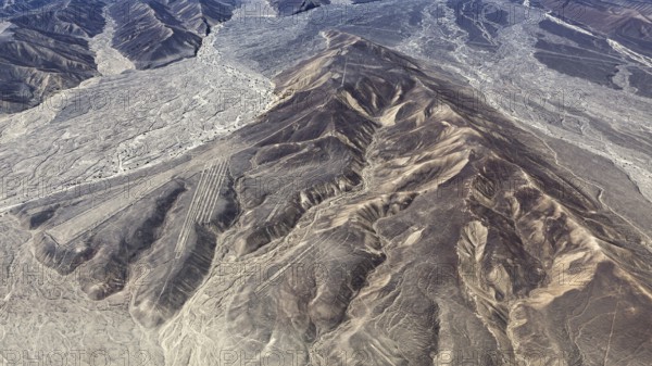 Mountain ranges in a dry desert landscape with clear geoglyph patterns, the geoglyphs and images in