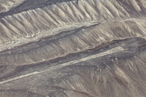 Aerial view of the drawn Nazca lines that cover sandy hills, the geoglyphs and drawings in the