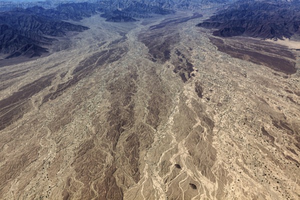 Impressive aerial view of a desert landscape with many earthy textures and furrows, central focus