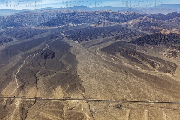 Extensive desert landscape with a long straight road, captured from above, The desert landscape
