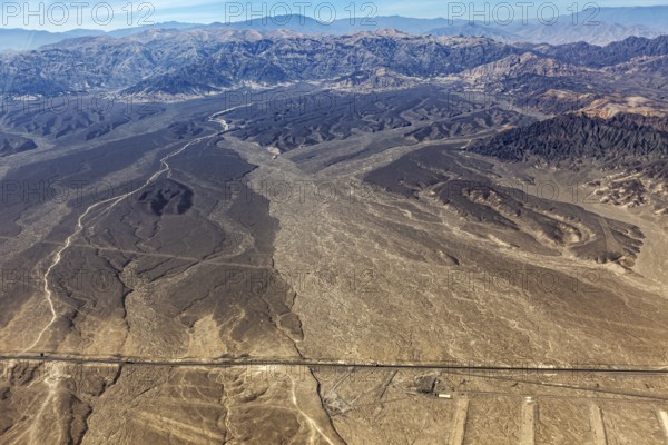 Extensive desert landscape with surrounding mountains photographed from a bird's eye view, The
