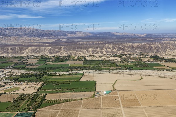 View of a mix of fields and dry landscapes with mountain range, The desert landscape near Nasca in