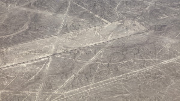 Aerial view of the Nazca lines in a barren desert landscape with geometric patterns, the geoglyphs