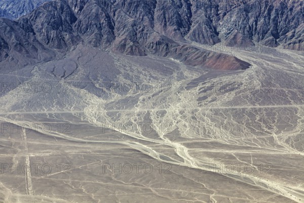 Erosion-prone desert landscape with rough mountain structures in the background, The desert