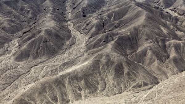 Hilly desert landscape with numerous engraved lines, geoglyphs and drawings in the desert near