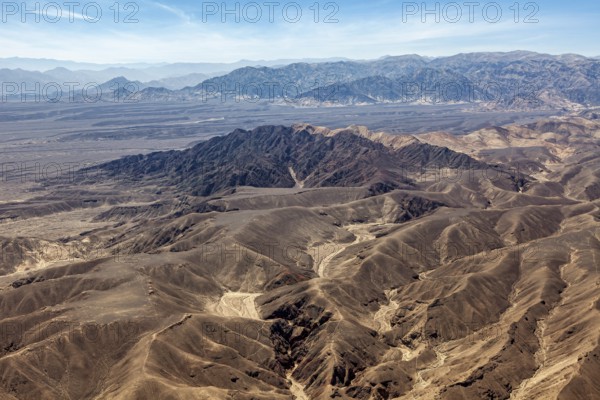 Breathtaking panorama of dry mountains in the desert under blue sky, the desert landscape near