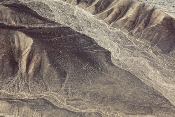 Aerial view of a desert with hills and ancient line formations, the geoglyphs and images in the