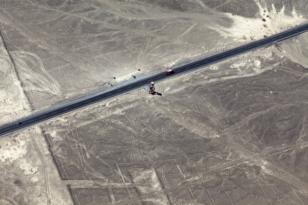 View of a road leading through a desert landscape with geoglyphs, the geoglyphs and paintings in