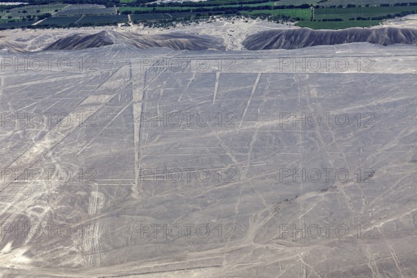 View of the desert with visible geoglyphs, fields and mountains lying in the distance, the