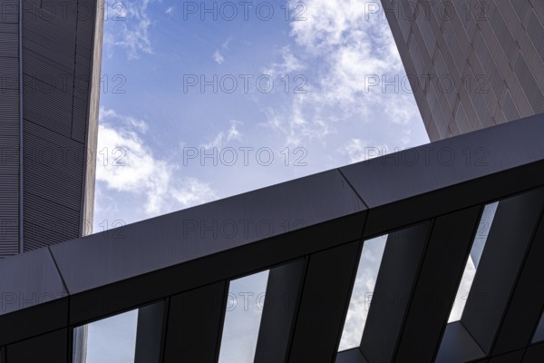 A detailed close-up of modern architecture featuring sharp lines and geometric forms against a