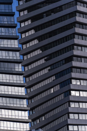 A detailed view of modern skyscraper exteriors featuring blue-tinted glass and staggered metal