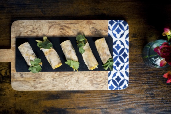 Delicious vegetable and courgette rolls elegantly arranged on a decorative wooden platter with