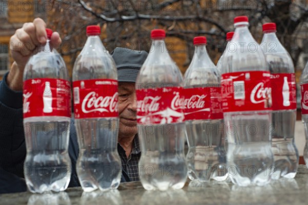 Sofia, Bulgaria. January 21st 2018 An old Bulgarian man filling Coca-Cola bottles with mineral