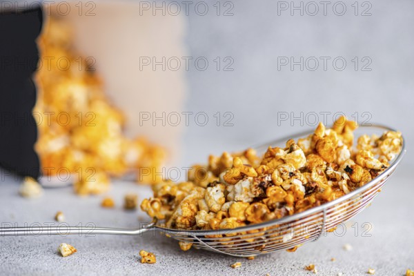 Gourmet sweet caramel popcorn in a shiny wire basket, the sugary golden pieces bathed in caramel