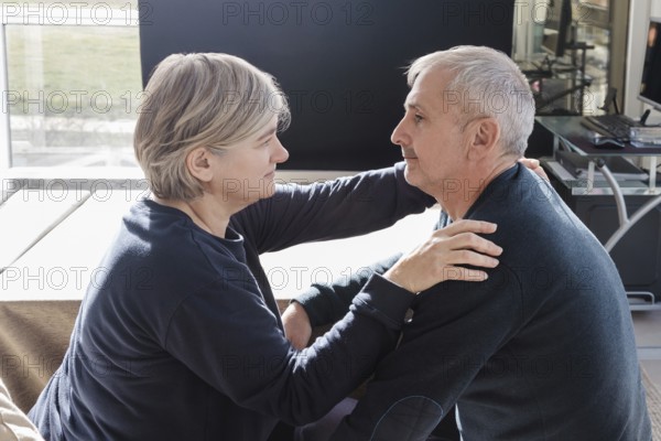 An elderly couple shares an intimate, tender moment in a cozy indoor setting The scene captures