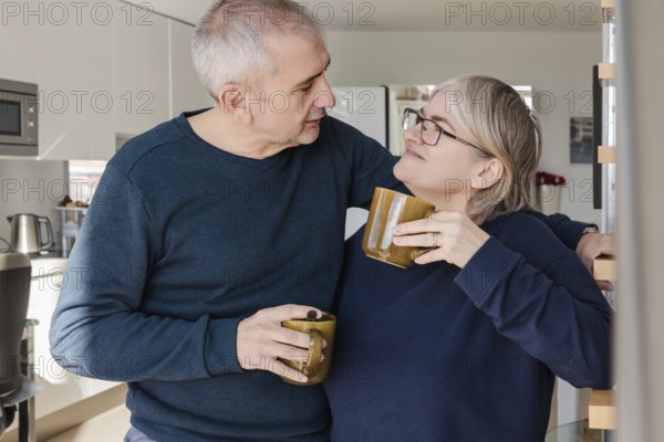 A senior couple, relaxed and happy, enjoying coffee together They share affectionate glances in a