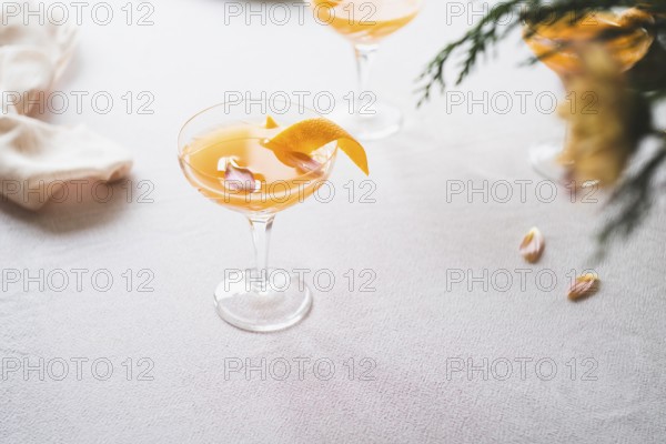 Elegant mandarin cocktail served in a stemmed glass, garnished with a twist of orange zest, on a