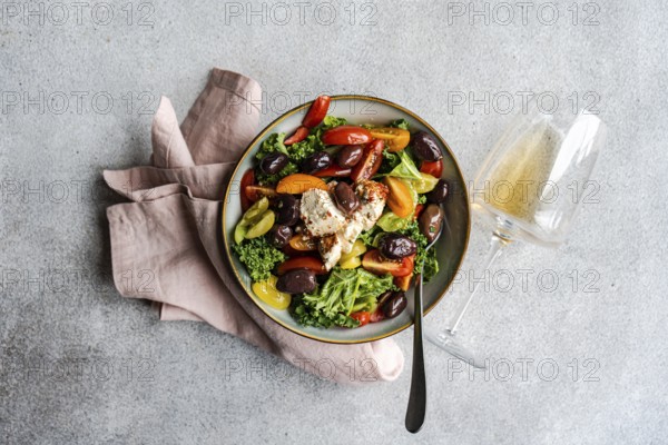 Top view of a vibrant healthy salad featuring raw kale leaves, a mix of colorful cherry tomatoes,