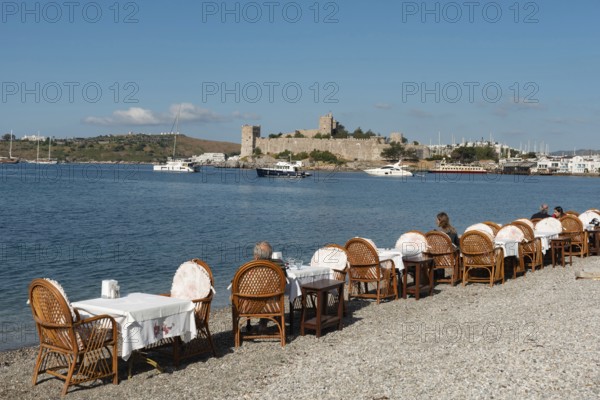 Bodrum, Mugla, Turkey. April 21st 2022 Restaurant Tables on the beach in Bodrum harbour with Bodrum