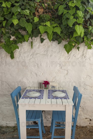 Pretty blue and white cafe restaurant table in a shaded side street in the popular tourist