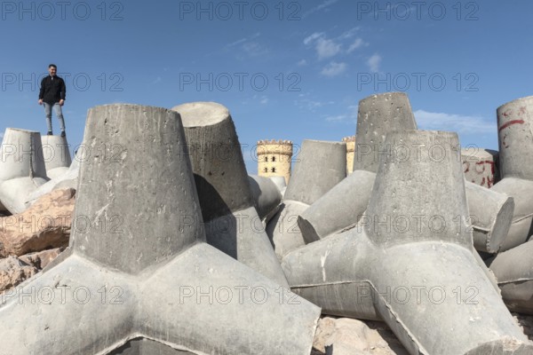 Alexandria, Egypt. December 1st 2022 Young Egyptian man standing on massive concrete blocks