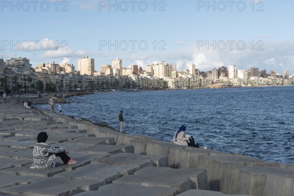 Alexandria, Egypt. December 1st 2022 Egyptian people on concrete blocks positioned as a defence