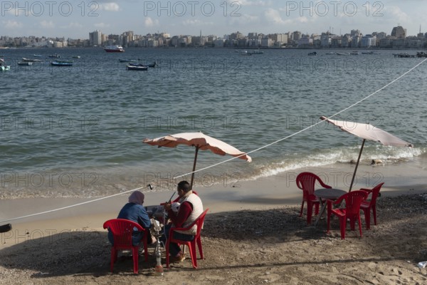 Alexandria, Egypt. December 1st 2022 An Egyptian couple sit on the receding Mediterranean beach of