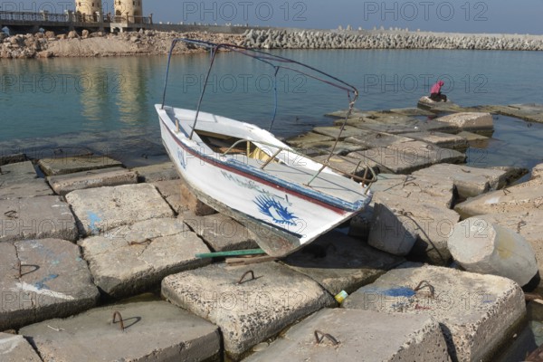 Alexandria, Egypt. December 1st 2022 Wooden boat abandoned on large concrete slabs designed to