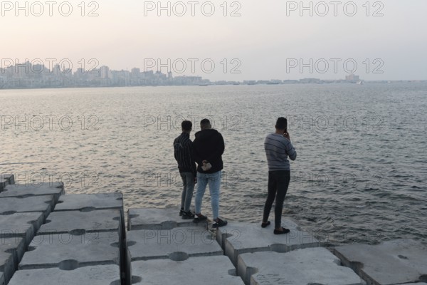 Alexandria, Egypt. December 1st 2022 Young Egyptian men standing on large concrete blocks designed